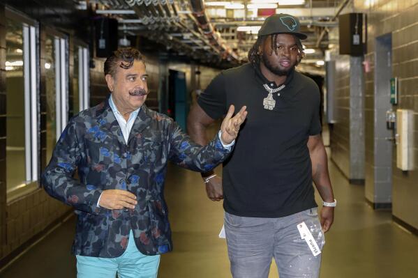 Jacksonville Jaguars owner Shad Khan walks first-round draft pick offensive lineman Anton Harrison, right, to an NFL football news conference in Jacksonville, Fla., Friday, April 28, 2023. (AP Photo/Gary McCullough)