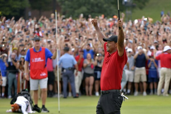 
              FILE - In this Sept. 23, 2018, file photo, Tiger Woods celebrates after on the 18t...