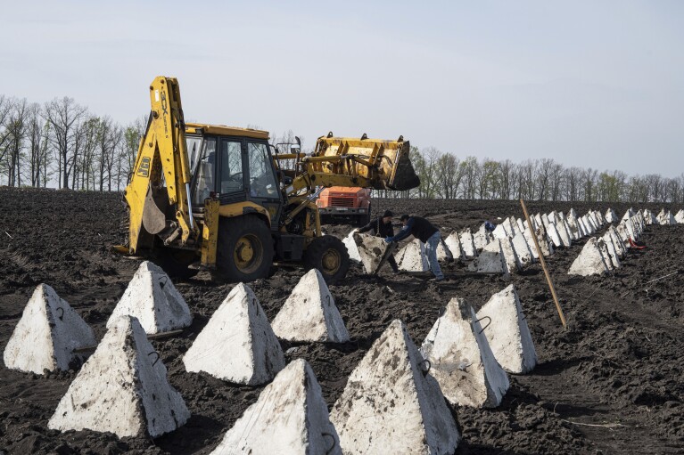 Workers install anti-tank systems known as “dragon teeth” during construction new defensive positions close to the Russian border in Kharkiv region, Ukraine, on Wednesday, April 17, 2024. (AP Photo/Evgeniy Maloletka)