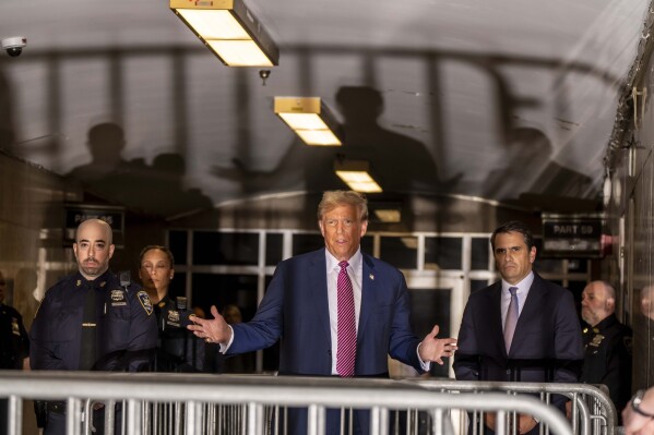 Former President Donald Trump speaks to the media alongside his attorney Todd Blanche, right, as they exit the courtroom following proceedings in his trial, Friday, April 19, 2024, at Manhattan Criminal Court in New York.  (Mark Peterson/Pool Photo via AP)