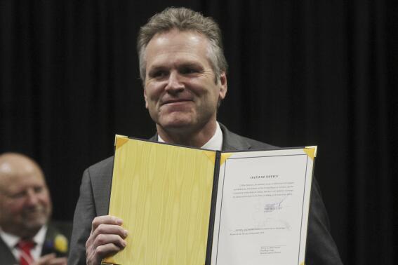 Gov. Mike Dunleavy holds his oath of office after he signed it during his inauguration ceremony Monday, Dec. 5, 2022, in Anchorage, Alaska. Dunleavy, a Republican, last month became the first Alaska governor since Democrat Tony Knowles in 1998 to win back-to-back terms. (AP Photo/Mark Thiessen)