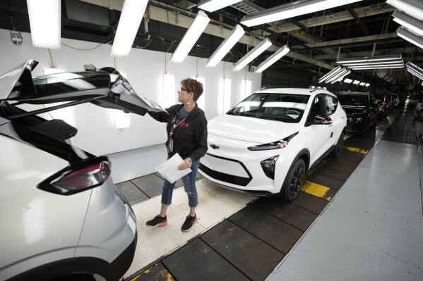 File - Assembly line worker Janice DeBono looks over a 2023 Chevrolet Bolt EUV at the General Motors Orion Assembly, June 15, 2023, in Lake Orion, Mich. General Motors reports earnings on Jan. 30, 2024. (AP Photo/Carlos Osorio, File)