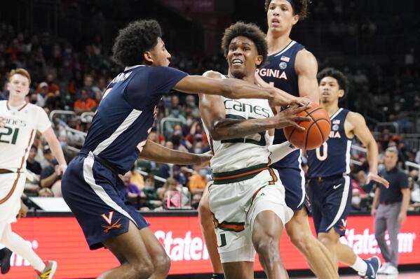 Virginia guard Reece Beekman (2) blocks Miami guard Kameron McGusty's (23) drive to the basket during the second half of an NCAA college basketball game, Saturday, Feb. 19, 2022, in Coral Gables, Fla. (AP Photo/Marta Lavandier)