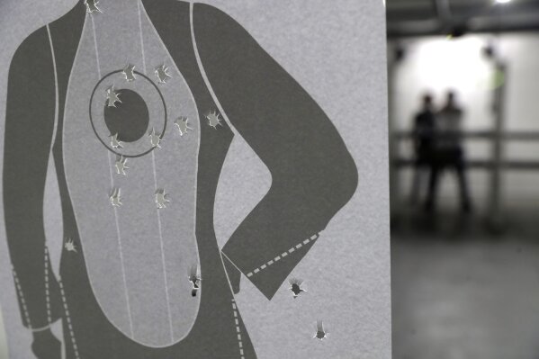 A target is perforated with bullet holes at the Valparaiso Shooting Club on the outskirts of Brasilia, Brazil, Thursday, March 4, 2021. Former national public security secretary Jose Vicente da Silva believes the presidential decrees on loosening gun control favor a small elite that can afford weapons without giving much back to a country where hundreds of policemen die each year and thousands are reportedly killed by gun violence. (AP Photo/Eraldo Peres)
