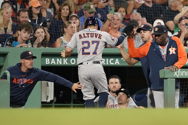 Houston Astros' Jose Altuve (27) is welcomed to the dugout after scoring on a single by Yordan Alvarez in the third inning of a baseball game against the Boston Red Sox, Monday, Aug. 28, 2023, in Boston. (AP Photo/Steven Senne)