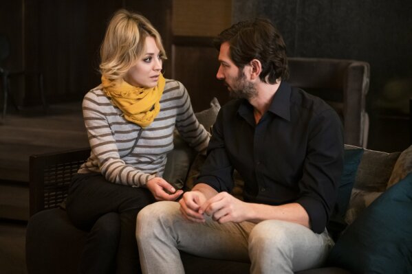 This image released by HBO Max shows Kaley Cuoco, left, and Michiel Huisman in a scene from "The Flight Attendant." The eight-episode series debuts on HBO Max on Nov. 26. (Phil Caruso/HBO Max via AP)