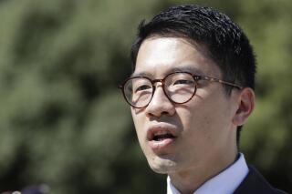 FILE - In this Tuesday, Aug. 25, 2020 file photo, Hong Kong activist Nathan Law takes part in a protest during a meeting of Chinese Foreign Minister Wang Yi with Italian Foreign Minister Luigi Di Maio, in Rome. A Hong Kong pro-democracy website was temporarily taken down after police warned the Israel-based hosting company that it breached a national security law, highlighting concerns about aggressive action by authorities in the Chinese city to muzzle online dissent abroad. Nathan Law, a Hong Kong opposition leader based in the U.K., tweeted Thursday, June 3, 2021 that the hosting company, Wix.com, received a request from the Hong Kong police department to disable the 2021 Hong Kong Charter website. (AP Photo/Andrew Medichini, File)