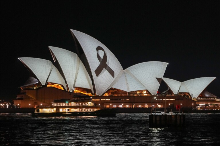 The Sydney Opera House is lit up with a black ribbon on Monday, April 15, 2024, as part of a national day of mourning following the deaths of several people at a shopping center on April 13.  Australian police are investigating why a lone gunman who stabbed several people to death in a busy Sydney shopping center and wounded more than a dozen others targeted women while avoiding men.  (AP Photo/Mark Baker)
