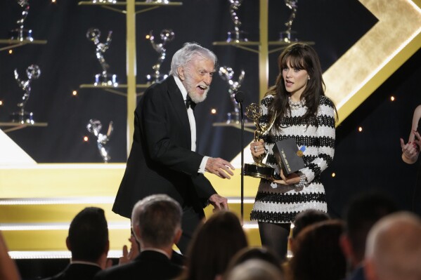 Zooey Deschanel, right, presents the award for outstanding guest performance in a daytime drama series to Dick Van Dyke for "Days of our Lives" during the 51st Daytime Emmy Awards on Friday, June 7, 2024, at the Westin Bonaventure in Los Angeles. (AP Photo/Chris Pizzello)
