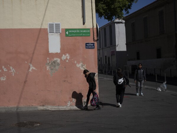 Students walk outside the mosque at Ibn Khaldoun, a private Muslim school, in Marseille, southern France, Tuesday, April 16, 2024. (AP Photo/Daniel Cole)