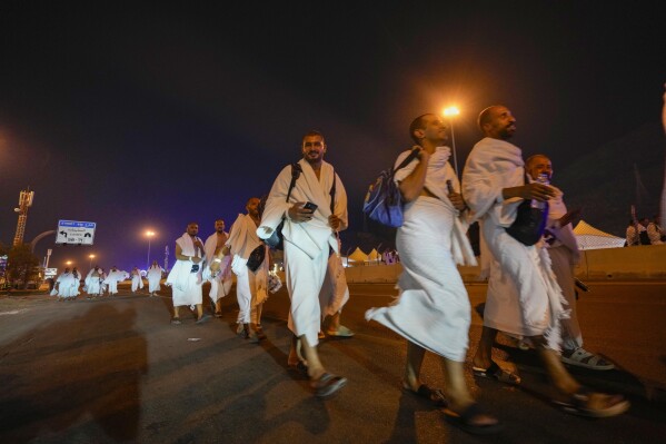 Muslim pilgrims arrive at the Mina tent camp during the annual Hajj pilgrimage, near the holy city of Mecca, Saudi Arabia, Friday, June 14, 2024. Hajj is the annual Islamic pilgrimage to Mecca in Saudi Arabia that is required once in a lifetime of every Muslim who can afford it and is physically able to make it. Some Muslims make the journey more than once. (AP Photo/Rafiq Maqbool)