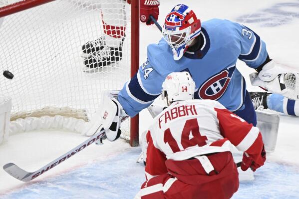 Detroit Red Wings' Robby Fabbri (14) scores against Montreal Canadiens goaltender Jake Allen (34) during overtime NHL hockey game action in Montreal, Thursday, Jan. 26, 2023. (Graham Hughes/The Canadian Press via AP)