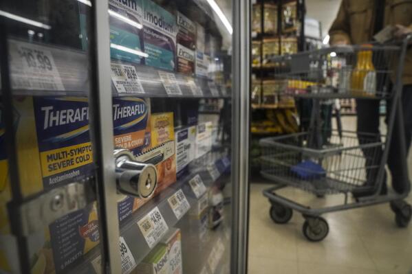 Pharmaceutical items are kept locked in a glass cabinet at a Gristedes supermarket, Tuesday Jan. 31, 2023, in New York. Increasingly, retailers are locking up more products or increasing the number of security guards at their stores to curtail theft. (AP Photo/Bebeto Matthews)