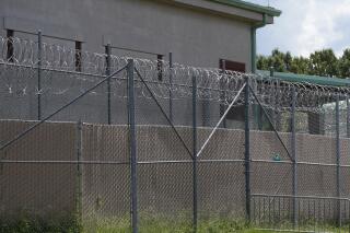 FILE - Rolls of razor wire line the top of the security fencing at the Raymond Detention Center in Raymond, Miss., Aug. 1, 2022. A man who escaped from the Mississippi jail on April 22, 2023, has been founded dead at a truck stop in New Orleans, authorities announced Tuesday, May 2. (AP Photo/Rogelio V. Solis, File)