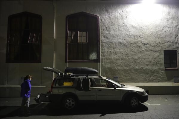 In this photo taken Oct. 10, 2017, Ellen Tara James-Penney, a lecturer at San Jose State University, prepares to stay the night inside her station wagon in the parking lot of Grace Baptist Church in San Jose, Calif. The booming economy along the West Coast has led to an historic shortage of affordable housing and has upended the stereotypical view of people out on the streets. Reporting by The Associated Press finds that many of them are employed, working as retail clerks, plumbers, janitors _ even teachers. They go to work, sleep where they can and buy gym memberships for a place to shower. (AP Photo/Marcio Jose Sanchez)