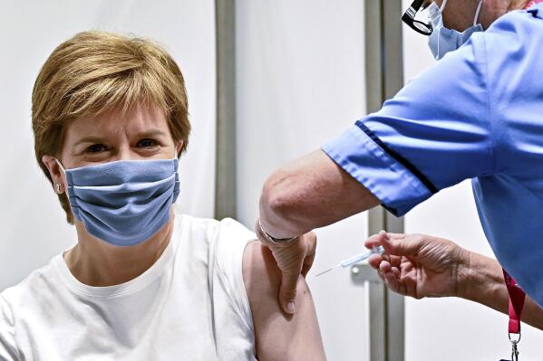 First Minister of Scotland Nicola Sturgeon receives her second dose of the AstraZeneca Covid-19 vaccine, administered by staff nurse Susan Inglis, at the NHS Louisa Jordan vaccine centre in Glasgow, Scotland, Monday June 21, 2021. (Jeff J Mitchell/Pool via AP)