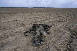 ARCHIVO - Un soldado ruso durante los combates contra el ejército ucraniano yace en un campo de maíz en Sytnyaky, a las afueras de Kiev, Ucrania, el domingo 27 de marzo de 2022. Casi 50.000 soldados rusos han muerto en la guerra en Ucrania, según un nuevo análisis estadístico. (AP Foto/Rodrigo Abd, Archivo)