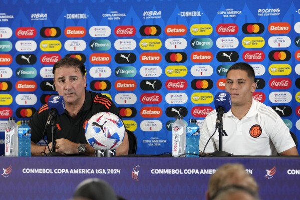 Colombia head coach Nestor Lorenzo, left, and midfielder Juan Fernando Quintero, right, speak during a Copa America soccer news conference, Saturday, July 13, 2024, in Miami Gardens, Fla. Colombia plays Argentina in the final Sunday. (AP Photo/Lynne Sladky)