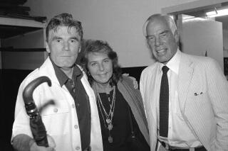 FILE - Actor Lee Marvin, right, and his wife, Pamela, visit with Mitchell Ryan, star of Arthur Miller's play "The Price," backstage at the Playhouse Theater in New York in July 1979. Ryan, who played a villainous general in the first “Lethal Weapon" movie, a ruthless businessman on TV's “Santa Barbara" and had character roles on the soap opera “Dark Shadows" and the 1990s sitcom “Dharma & Greg," died Friday, March 4, 2022. He was 88. Ryan died of congestive heart failure at his Los Angeles home, his stepdaughter, Denise Freed, told the Hollywood Reporter. (AP Photo/Dan Grossi)