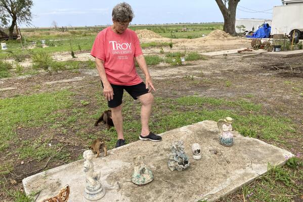 On Saturday, May 22, 2021, Grand Chenier, La., resident Margaret Little looks at some decorations and objects that had been around her home and that she recovered after Hurricane Laura destroyed her home last year. (AP Photo/Rebecca Santana)