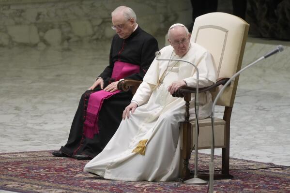 Pope Francis touches his right knee during his weekly general audience at the Vatican, Wednesday, March 2, 2022. (AP Photo/Gregorio Borgia)