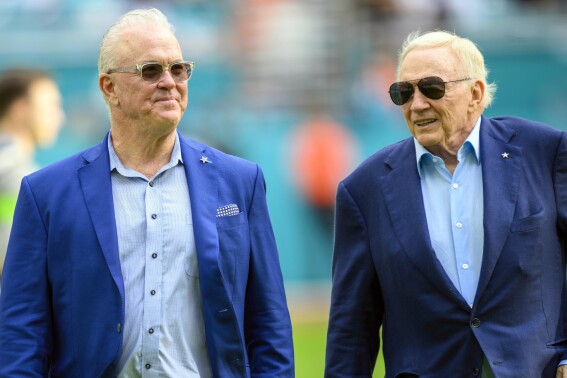 FILE - Dallas Cowboys chief operating officer Stephen Jones, left, and Cowboys owner Jerry Jones talk on the field before an NFL football game against the Miami Dolphins, Sunday, Dec 24, 2023, in Miami Gardens, Fla. The Dallas Cowboys are resetting at running back eight years after drafting Ezekiel Elliott. (AP Photo/Doug Murray, FIle)