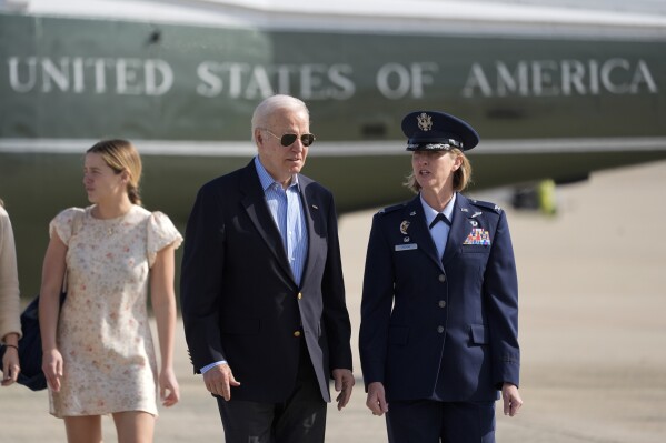 President Joe Biden is escorted by Air Force Col. Angela Ochoa, Commander, 89th Airlift Wing, as he arrives at Andrews Air Force Base, Md., Wednesday, June 12, 2024. Biden is headed to Italy for the G7 summit. Biden's granddaughter, Finnegan Biden, walks left. (AP Photo/Alex Brandon)