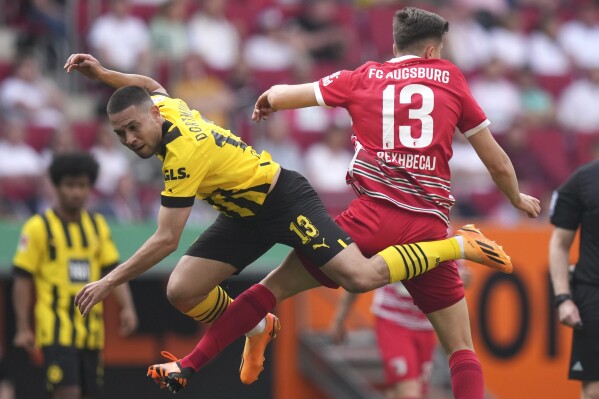 FILE - Dortmund's Raphael Guerreiro, left, challenges Augsburg's Elvis Rexhbecaj for the ball during the German Bundesliga soccer match between FC Augsburg and Borussia Dortmund at the WWK Arena in Augsburg, Germany, May 21, 2023. Bayern Munich signed Portugal left back Raphaël Guerreiro on a free transfer Friday June 23, 2023, from Bundesliga rival Borussia Dortmund. (AP Photo/Matthias Schrader, File)