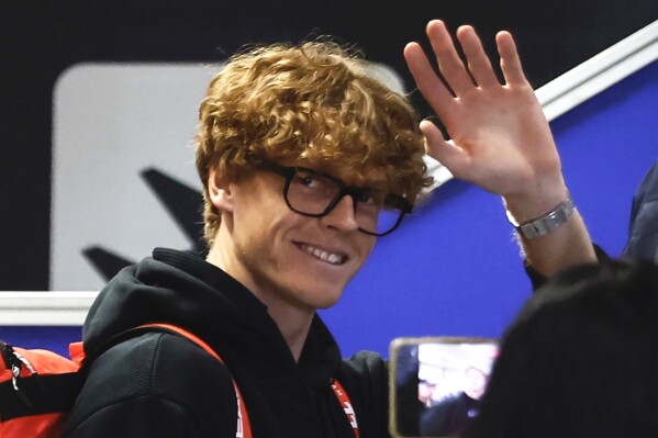 Australian Open champion Jannik Sinner waves to fans as he arrives at Leonardo da Vinci airport in Fiumicino, Italy, Tuesday, Jan. 30, 2024. Sinner has returned to Italy amid great fanfare with RAI state TV broadcasting live his arrival at the Rome airport. (Cecilia Fabiano/LaPresse via AP)
