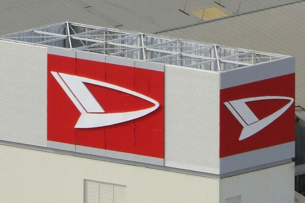 FILE - This aerial photo shows the logo of Daihatsu Motor Co. at its headquarters in Ikeda, north of Osaka, Japan, on Dec. 20, 2023. The Japanese automaker that cheated on safety tests for decades said Monday, Jan. 22, 2024, it doesn't expect to resume shipping cars any time soon. The Japanese government ordered Daihatsu, a subsidiary of Toyota, to halt production of its entire lineup after reports of faked safety test results emerged last year. (Kyodo News via AP, File)