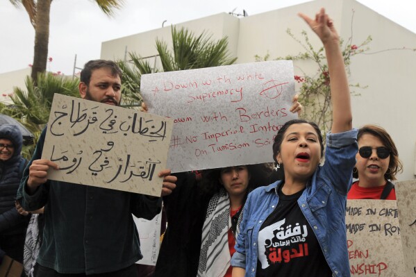 Activists demonstrate outside the delegation of the European Union to Tunisia against migrant deals with EU, in the capital Tunis, Thursday, May 9, 2024. Tensions in Tunisia are ratcheting up as authorities increasingly targeting migrants communities from the country's shoreline to its capital, where protestors staged a sit-in in front of European Union headquarters on Thursday. Banner in Arabic reads "Speeches in Carthage, decisions in Rome." (AP Photo/Anis Mili)