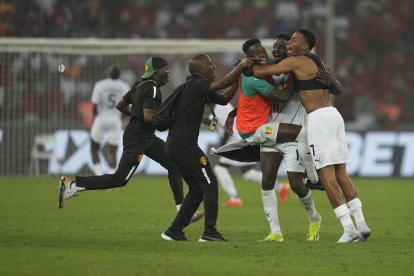 Members of Guinea's te4am jubilate after Guinea's Mohamed Bayo scored the winning goal during the African Cup of Nations Round of 16 soccer match between Equatorial Guinea and Guinea, at the Olympic Stadium of Ebimpe in Abidjan, Ivory Coast, Sunday, Jan. 28, 2024. (AP Photo/Themba Hadebe)