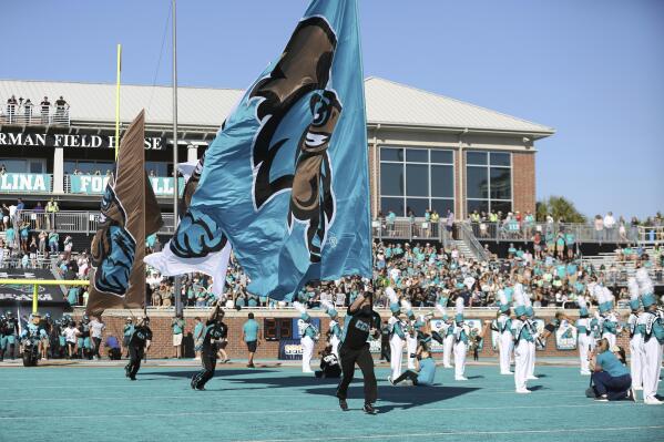 FILE - The Coastal Carolina cheerleaders lead the team onto the field before an NCAA college football game against Georgia State on Nov. 13, 2021, in Conway, S.C. What looked like a week of opportunity for No. 23 Coastal Carolina quickly became one of grief and unconditional support for the University of Virginia football team the Chants were supposed to play on Saturday, Nov. 19, 2022. That game was called off Wednesday, Nov. 16, as Virginia continued grieving their three football players killed by a former member of the Cavaliers last Sunday night, Nov. 13. (AP Photo/Artie Walker, Jr., File)