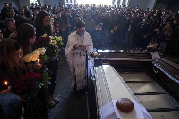 A priest conducts a funeral service of teenager Danylo Khudia, and his parents Viktoria and Oleh Khudia, killed in a Russian strike on a residential neighbourhood on April 24, during a farewell ceremony at the crematorium in Kyiv, Ukraine, Monday, April 28, 2025. (AP Photo/Evgeniy Maloletka)