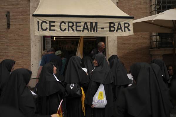 Nuns enter an ice cream coffee bar near the Vatican, in Rome, on Wednesday, May 7, 2025, on the day cardinals sequester themselves at the Vatican for the start of a conclave to elect the 267th Roman pontiff, a successor to Pope Francis. (AP Photo/Francisco Seco)