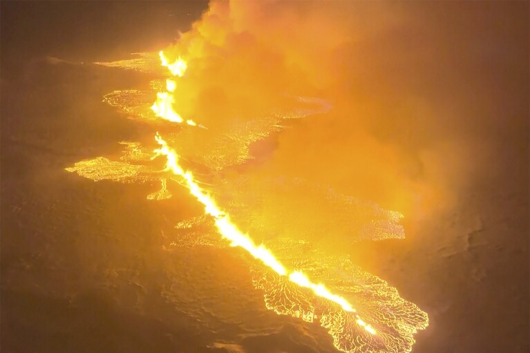 This image made from video provided by the Icelandic Coast Guard shows magma flow on a hill near Grindavik on Iceland's Reykjanes Peninsula sometime around late Monday, Dec. 18, or early Tuesday, Dec. 19, 2023. A volcanic eruption started Monday night on Iceland's Reykjanes Peninsula, turning the sky orange and prompting the country's civil defense to be on high alert. (Icelandic coast guard via AP)