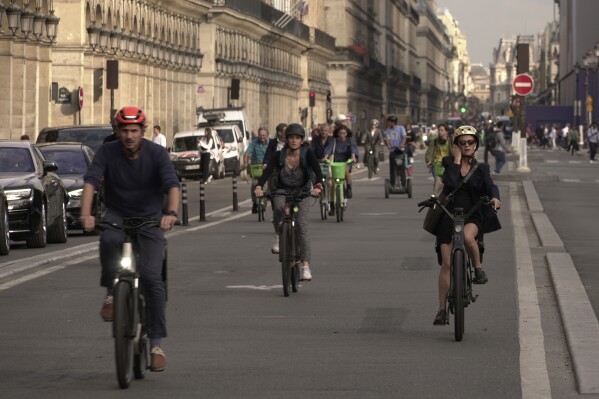 People ride on Rivoli street in Paris, Wednesday, Sept. 13, 2023. Years of efforts to turn car-congested Paris into a more bike-friendly city are paying off ahead of the 2024 Olympics, with increasing numbers of people using the French capital's growing network of cycle lanes. (AP Photo/John Leicester)