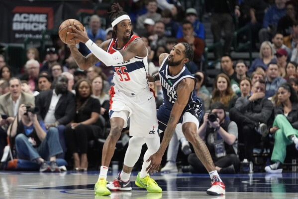 Washington Wizards guard Delon Wright (55) keeps the ball from Dallas Mavericks forward Derrick Jones Jr. (55) during the first half of an NBA basketball game in Dallas, Monday, Feb. 12, 2024. (AP Photo/LM Otero)