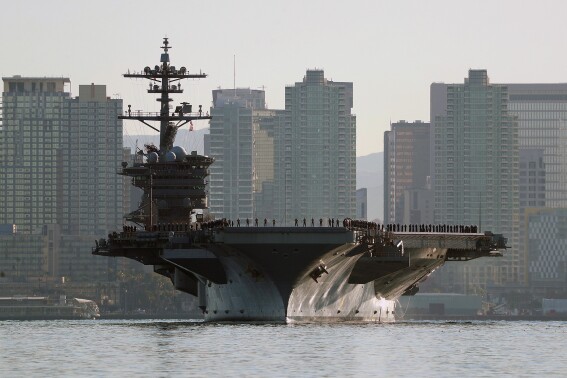 Sailors and marines line the deck of the aircraft carrier USS Abraham Lincoln (CVN-72) as it deploys from San Diego on Jan. 3, 2022. Two of the most populous states and two of the largest cities in the U.S. filed requests for corrections to their 2020 census figures at the end of last month. The slip-up, so to speak, reportedly took place on the aircraft carrier USS Abraham Lincoln. California officials believe its more than 5,000 crew members were wrongly assigned to San Diego's population total instead of neighboring National City's figures. (K.C. Alfred/The San Diego Union-Tribune via AP)