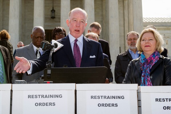 Dr. Steven Hotze, president of Conservative Republicans of Texas, speaks at a Restrain the Judges news conference, while Janet Porter of Faith2Action listens at right, in front of the Supreme Court in Washington, April 27, 2015. (AP Photo/Cliff Owen, File)
