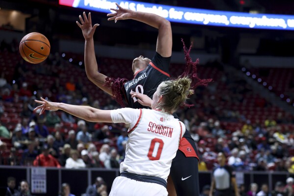 San Diego State guard Mia Davis (10) loses control of the ball after colliding with UNLV guard Ashley Scoggin (0) during the first half of an NCAA college basketball game for the championship of the Mountain West women's tournament Wednesday, March 13, 2024, in Las Vegas. (AP Photo/Ian Maule)