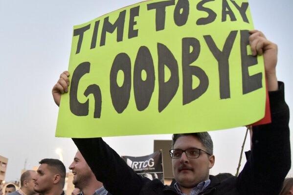 
              In this March 23, 2019, photo, a man holds a banner during a protest against President Milo Djukanovic in Montenegro's capital Podgorica. The anti-government demonstrations came as s...