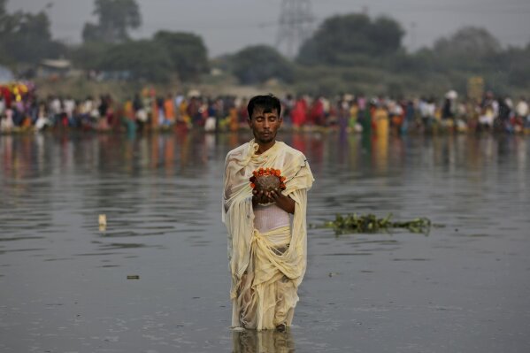A Hindu devotee prays to the Sun god as he stands in knee deep waters in River Yamuna during Chhath Puja festival in New Delhi, India, Thursday, Oct. 26, 2017. During Chhath, an ancient Hindu festival, rituals are performed to thank the Sun god for sustaining life on earth. (AP Photo/Altaf Qadri)