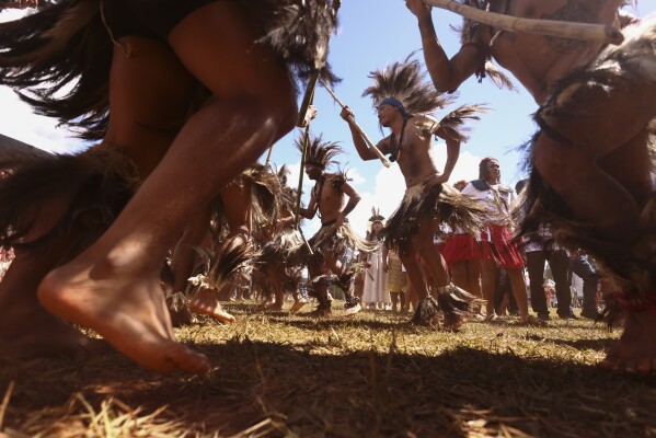 Indigenous people dance during the opening ceremony of the 20th annual Free Land Indigenous Camp in Brasilia, Brazil, Monday, April 22, 2024. The 7-day event aims to show the unity of Brazil's Indigenous peoples in their fight for the demarcation of their lands and their rights. (AP Photo/Luis Nova)