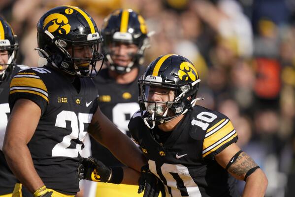Iowa wide receiver Arland Bruce IV (10) celebrates with teammate Gavin Williams (25) after scoring on a 2-yard touchdown run during the first half of an NCAA college football game against Illinois, Saturday, Nov. 20, 2021, in Iowa City, Iowa. (AP Photo/Charlie Neibergall)