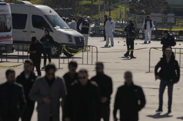 Security officers check the site where two attackers were killed outside a courthouse in Istanbul, Turkey, Tuesday, Feb. 6, 2024. Two people were shot dead while trying to attack a courthouse in Istanbul on Tuesday, Turkish Interior Minister Ali Yerlikaya said. (AP Photo/Francisco Seco)