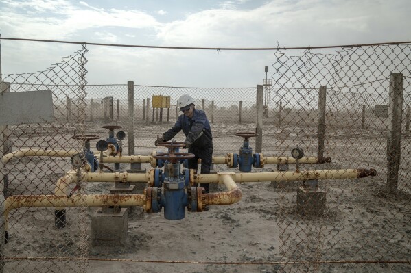 A person works in a gas field that was built in the desert that used to be the bed of the Aral Sea, on the outskirts of Muynak, Uzbekistan, Sunday, June 25, 2023. The discovery of oil and natural gas in the Aral's former seabed brought the building of gas production facilities, and shows that Uzbekistan has little interest in restoration, experts said. (APPhoto/Ebrahim Noroozi)