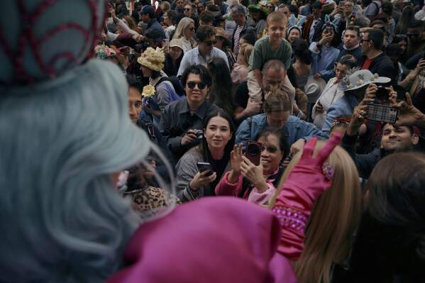 People take photos of a reveler wearing a decorated hat and costume during the annual Easter Parade and Bonnet Festival in front of St. Patrick's Cathedral on Sunday, April 20, 2025, in New York. (AP Photo/Andres Kudacki)