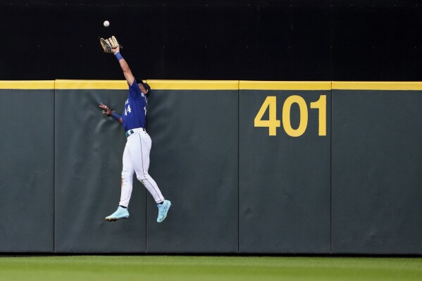 Seattle Mariners center fielder Julio Rodriguez catches a fly ball from San Diego Padres' Fernando Tatis Jr. during the fourth inning of a baseball game Tuesday, Aug. 8, 2023, in Seattle. (AP Photo/Lindsey Wasson)