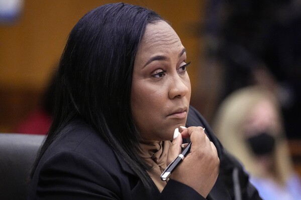 FILE - Fulton County District Attorney Fani Willis watches proceedings during a hearing to decide if the final report by a special grand jury looking into possible interference in the 2020 presidential election can be released Jan. 24, 2023, in Atlanta. Just one month after Donald Trump’s January 2021 phone call to suggest Georgia’s secretary of state could overturn his election loss, Willis announced she was looking into possibly illegal “attempts to influence” the results. (AP Photo/John Bazemore, File)